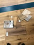 Verschiedene Holzfußbodenmuster, darunter große Dielen, Musterbücher und kleine Musterplatten, auf einem Holzboden.