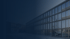 Modernes Bürogebäude mit vielen Fenstern und dunklem Hintergrund.