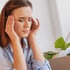 Woman holding her temples, experiencing a headache or migraine.