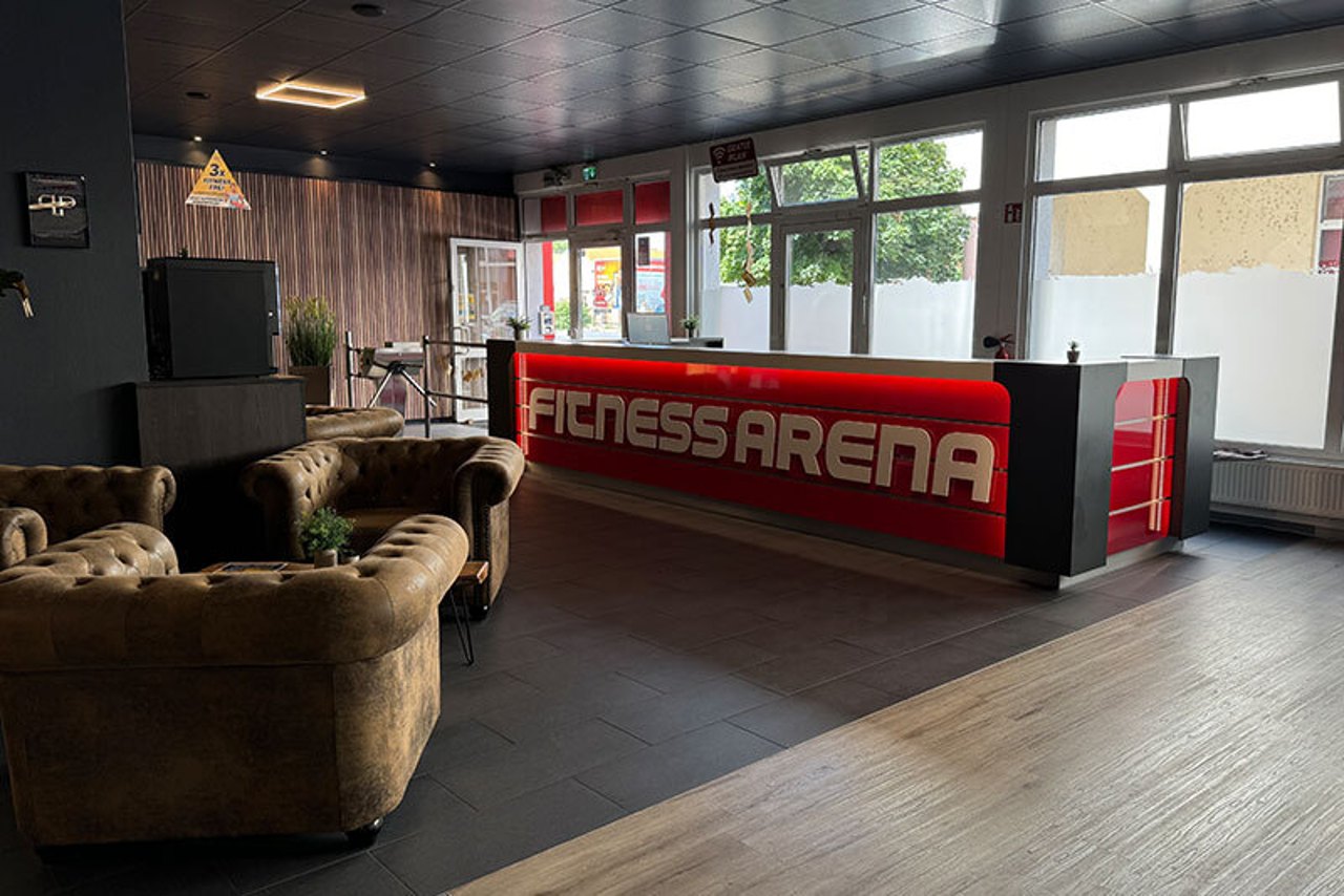 Empfangsbereich der Fitness Arena Coswig mit beleuchtetem Tresen