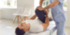 Ein Physiotherapeut dehnt das Bein eines Patienten, der auf einer Behandlungsliege liegt.