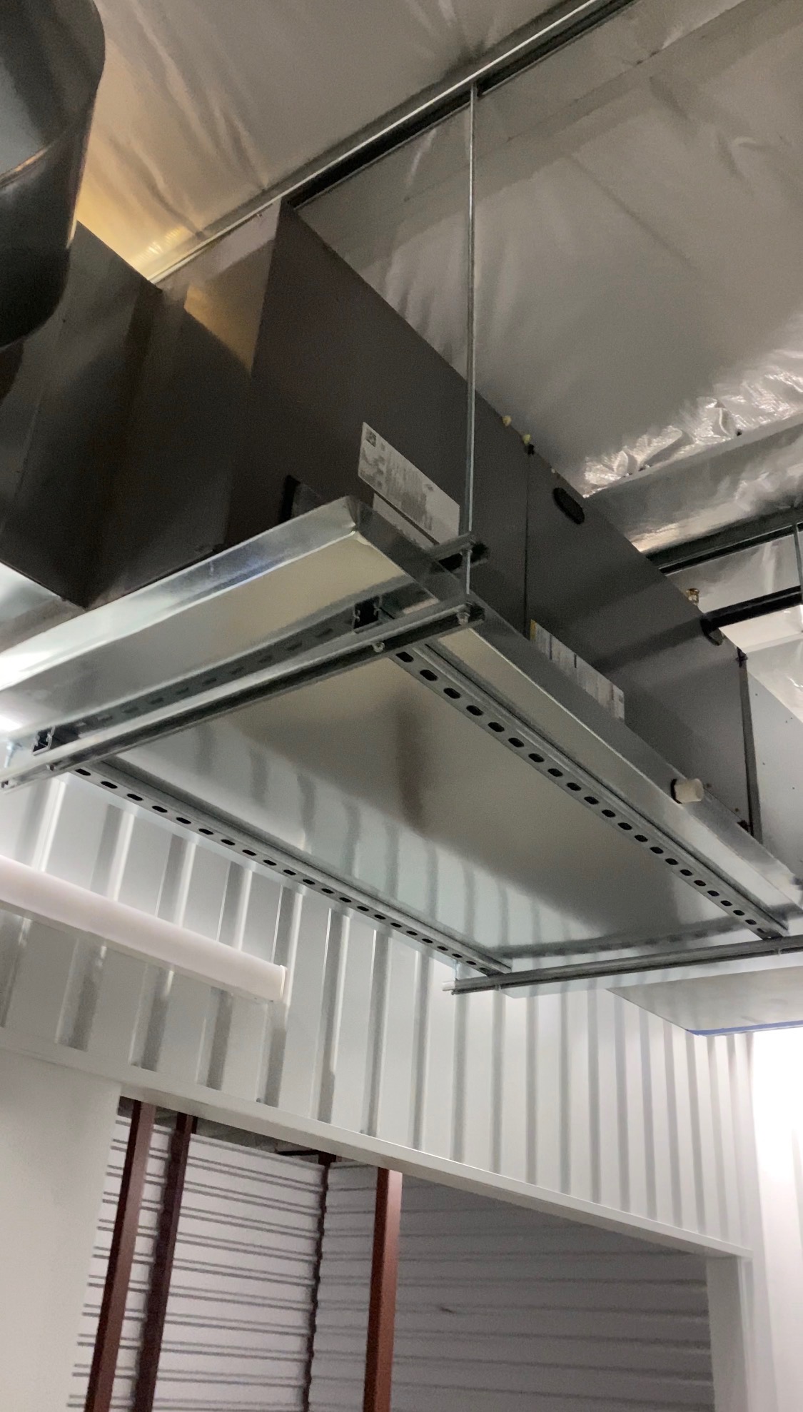 Commercial air handler return air grille and filter rack suspended from a ceiling
