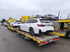 Vier Autotransporter der Hess Fahrzeuglogistik mit geladenen Fahrzeugen auf einem Parkplatz.