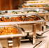 Serviertes Buffet mit mehreren Chafing Dishes, gefüllt mit verschiedenen warmen Speisen.