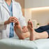 A doctor examines the sole of a patient's foot to check for neuropathy.