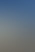 Große weiße Wanne auf einem Tieflader, gezogen von einem weißen LKW, unter blauem Himmel.