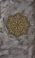 Goldenes florales Mandala-Symbol auf einer grau strukturierten Betonwand.