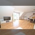 Geräumiges Wohnzimmer mit Holzboden, großem Fenster, TV-Möbel und Esstisch.