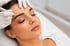 Frau mit geschlossenen Augen erhält ein Microblading der Augenbrauen.