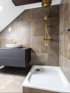 Modern saniertes Badezimmer mit dunklen Fliesen, Waschtisch und bodennaher Dusche