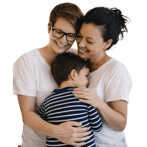 Two women smiling, one holding a baby wearing striped clothing.