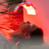 Woman with protective eyewear under a red light therapy machine.