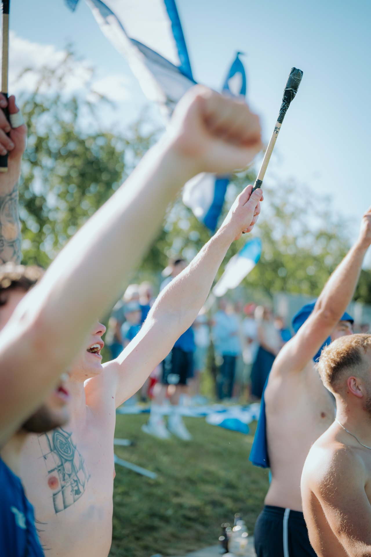 Erhobene Arme und Fahnen im Fanblock