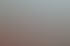 Ein lächelndes Paar stößt in einem Außenrestaurant mit Weingläsern an, im Hintergrund Berge und blauer Himmel.