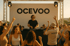 DJ spielt Musik vor tanzenden Menschen auf einem Festival mit einem „OCEVOO“-Banner im Hintergrund.