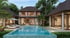 Luxury villa with a large rectangular swimming pool and lounge chairs.
