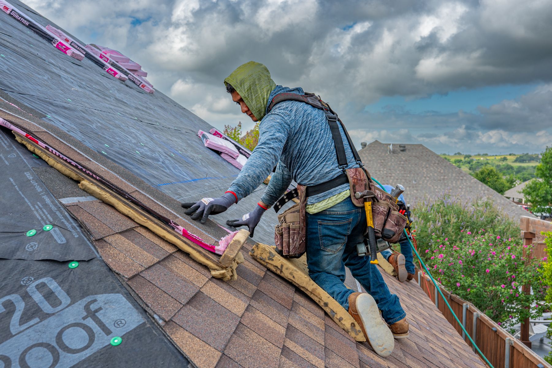 Roofing crew fastening new asphalt shingles on a North Texas home