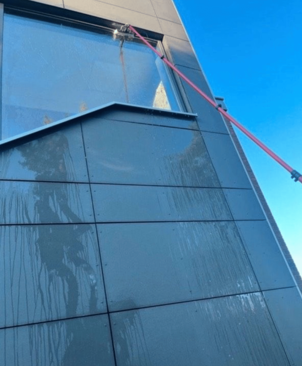 Glasfassadenreinigung in Berlin: Reinigung einer schwer erreichbaren Glasfläche in großer Höhe.