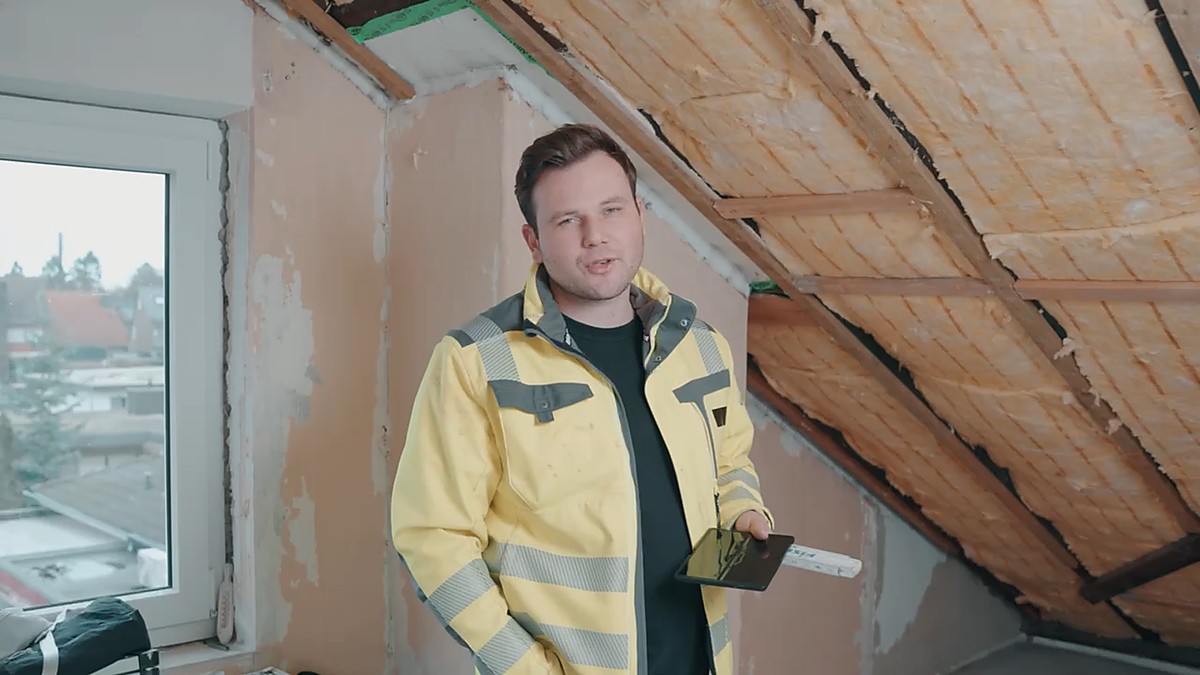 Maximilian Robens dokumentiert die Dachdämmung mit dem Tablet