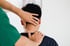 A chiropractor giving a neck adjustment to a male patient.
