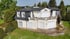 Reinigung von luxuriösem Einfamilienhaus, weißer Fassade und dunklem Schieferdach.