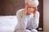 A woman holds her head in her hands, experiencing pain.