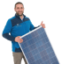 Mann in blauer Fleecejacke hält ein Solarmodul und zeigt einen Daumen hoch.