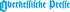 „Oberhessische Presse“ in blauer, altdeutscher Schrift auf dunkelgrünem Hintergrund.