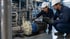 Engineer inspecting industrial pumping equipment in a process plant.