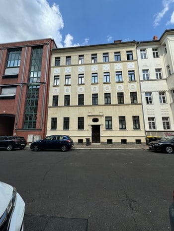 Frontansicht des Wohnhauses mit hellem Putz und mehreren Fensterreihen