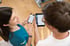 Therapeut LANDphysio Lauchdorf zeigt Mitglied digitalen Therapieplan und Trainingsauswertung auf Smartphone und Tablet