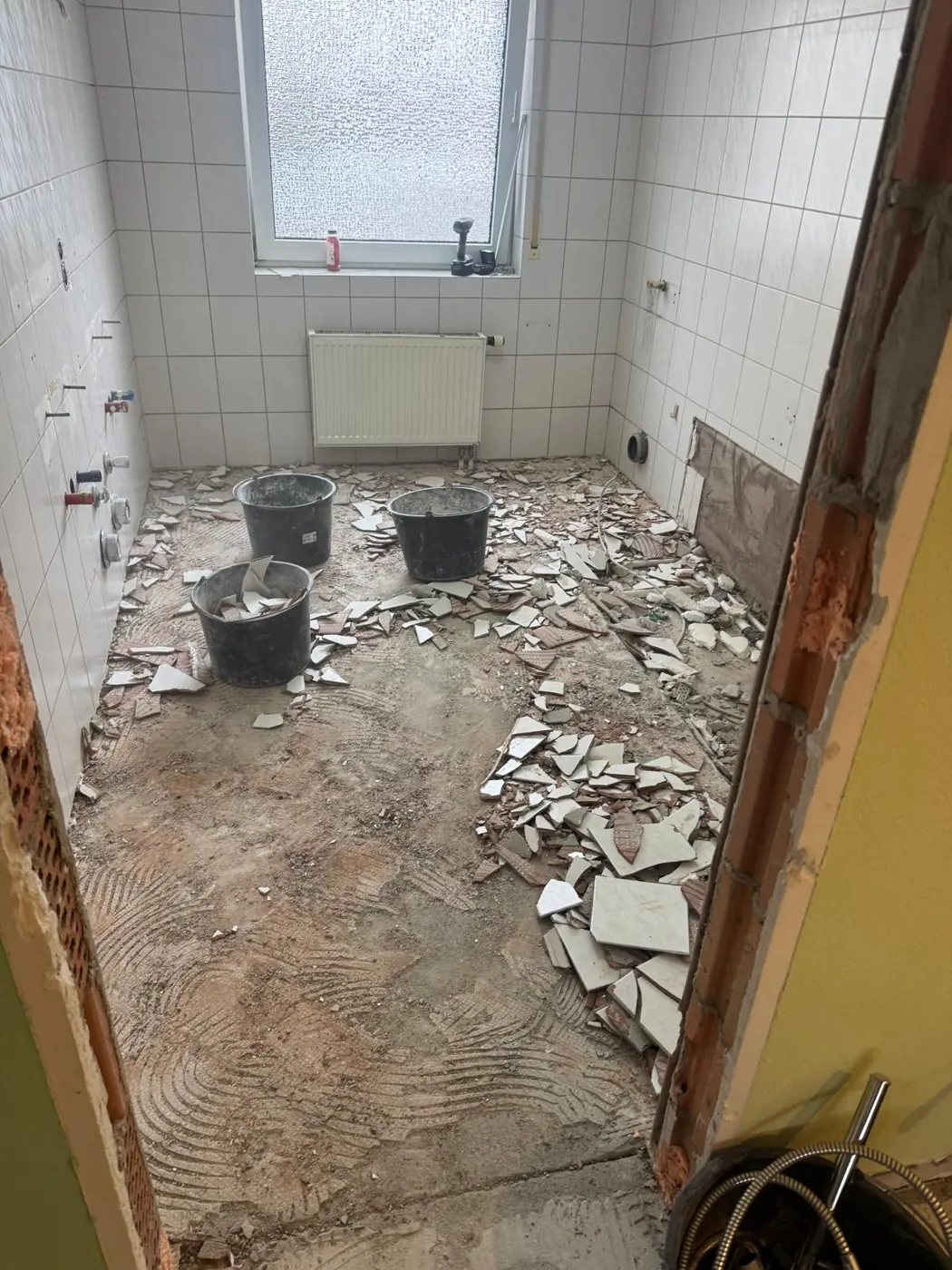Altes Bad mit Fliesen, Wanne und Duschtasse beim Abbruch