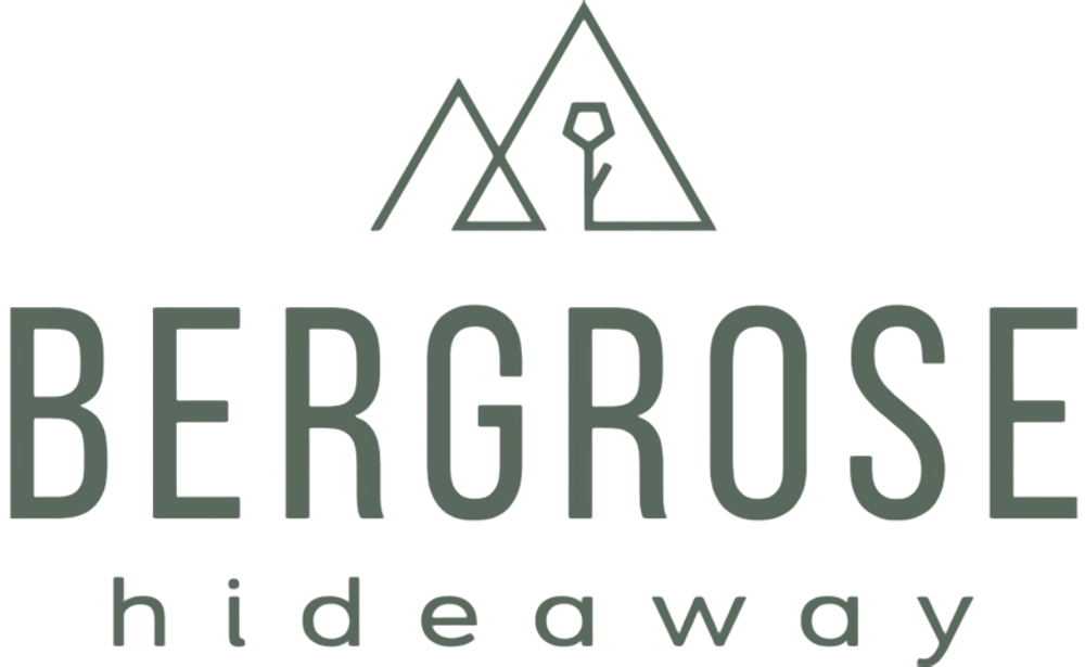Schriftzug "BERGROSE hideaway" mit stilisierten Bergen und einer Blüte