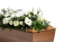 Blumengesteck mit weißen Rosen und grünen Akzenten auf Sarg