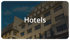 Fassade eines mehrstöckigen Hotelgebäudes mit dem Schriftzug Hotels vor blauem Himmel.