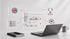 3D-Symbole für Webdesign, Programmierung und SEO schweben über einem Laptop auf einem Schreibtisch mit Notizbuch und Tasse.