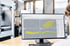 Ein Computermonitor zeigt eine CAD-Software mit gelben 3D-Modellen einer orthopädischen Einlage in einer Werkstattumgebung.