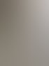 Frische Ausgleichsmasse wird mit einem Rakel auf einem Betonboden vor einer sanierungsbedürftigen Wand verteilt.