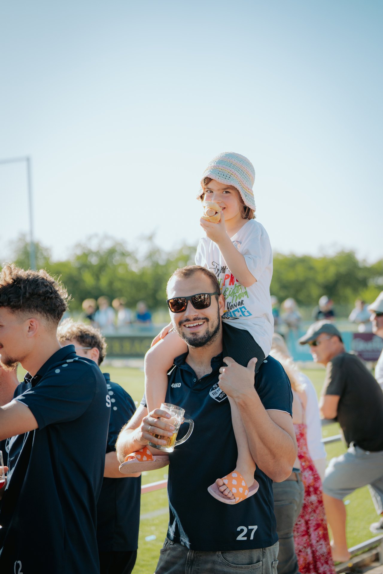 Kind auf Schultern, Wurst und Bier am Spielfeldrand