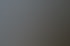 Ein gemütliches Wohnzimmer mit brennendem Kamin, Strickkissen und einer Decke auf einem Sessel.