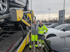 Zwei Männer in Warnwesten posieren lächelnd vor einem Autotransporter mit mehreren Neuwagen, KA-S 5344E Kennzeichen.
