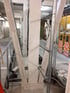 Betonstütze mit V-förmigen Streben, Verkabelung und elektrischen Schaltschränken in einem Industrieraum.