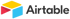 Airtable Logo mit einem gelben, roten und blauen Würfel neben dem Wort „Airtable“.