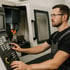 Mann mit Schutzbrille bedient eine CNC-Fräsmaschine in einer Werkstatt.