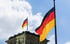 Deutschlandfahne am Bundestag in Berlin bei blauem Himmel