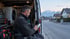Installateur im Servicebus prüft frühmorgens am Smartphone eingehende Anfragen aus seiner Google-Kampagne