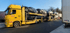 Autotransporter mit schwarzen Fahrzeugen beladen.