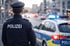 Rückenansicht eines Polizisten in Uniform mit reflektierender Weste, auf der "POLIZEI" steht.