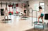 Drei Frauen trainieren auf Trampolinen in einem Fitnessstudio mit großem Fenster.