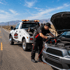 Towing Corona jump start service restoring power to a stranded vehicle with a dead battery on the roadside.
